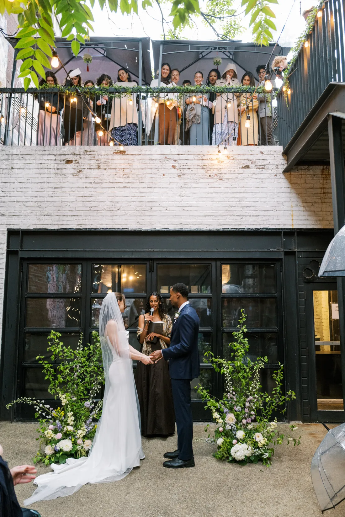 Wedding ceremony in the Maketto courtyard with guests watching from the balcony above