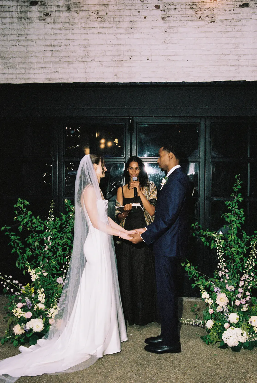 Bride and groom exchanging vows between meadow floral installations at Maketto in Washington DC