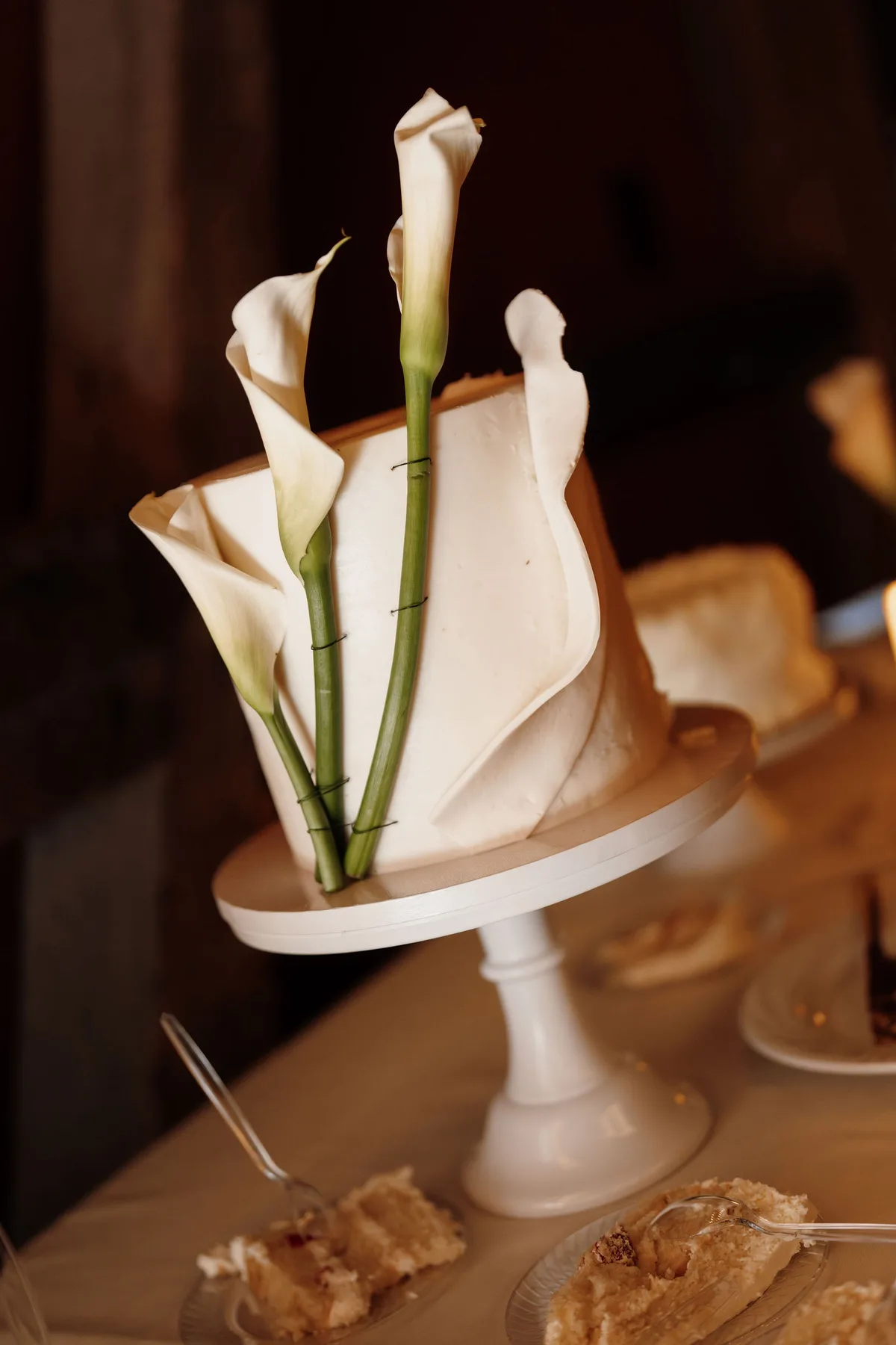 Fresh calla lilies wired into a sculptural buttercream wedding cake