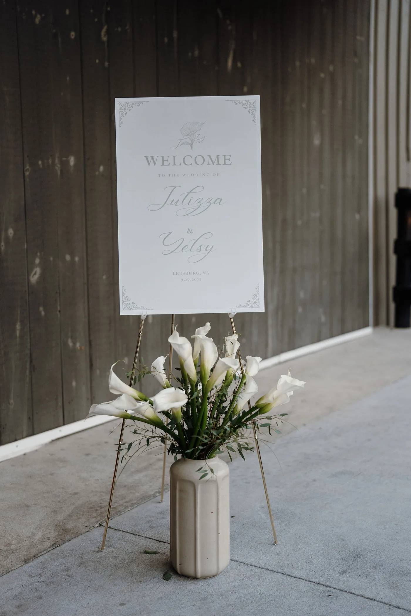 Tall calla lily arrangement beside a wedding welcome sign at a Leesburg barn venue
