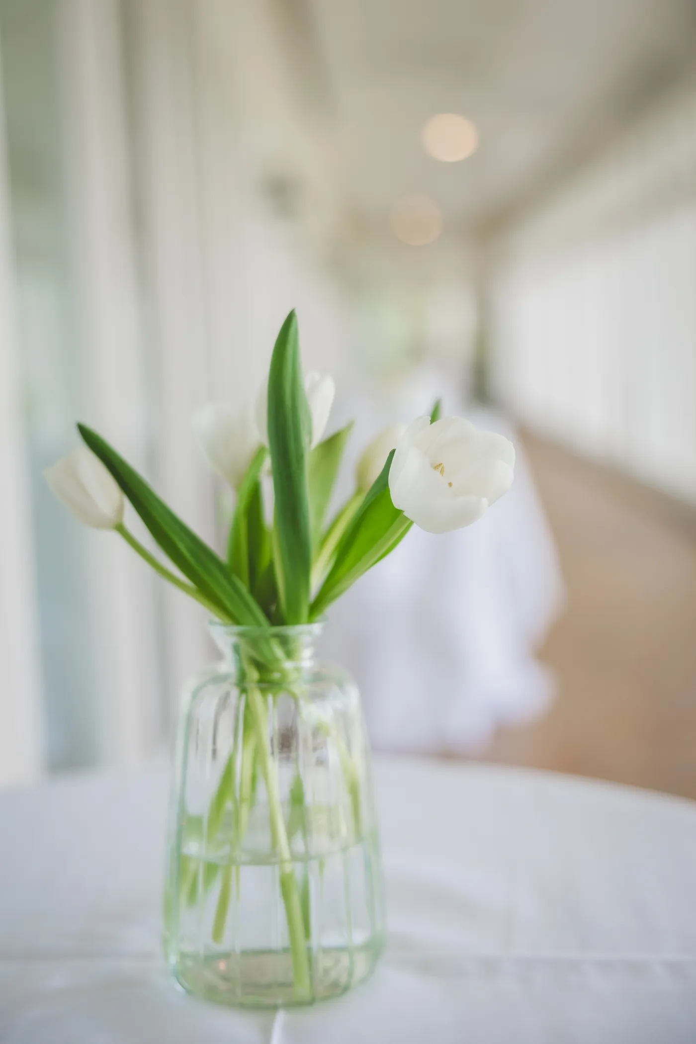 White tulips in a glass vase wedding arrangement